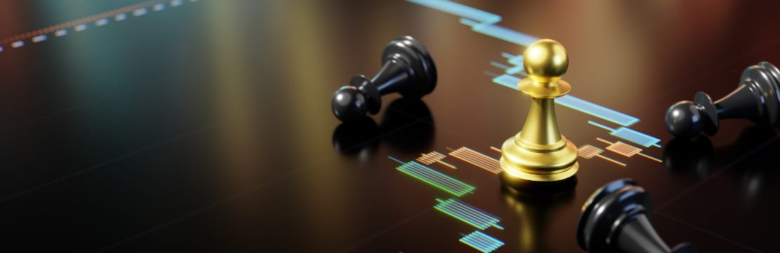 A gold pawn stands upright among fallen black chess pieces on a glossy surface displaying colorful financial charts.